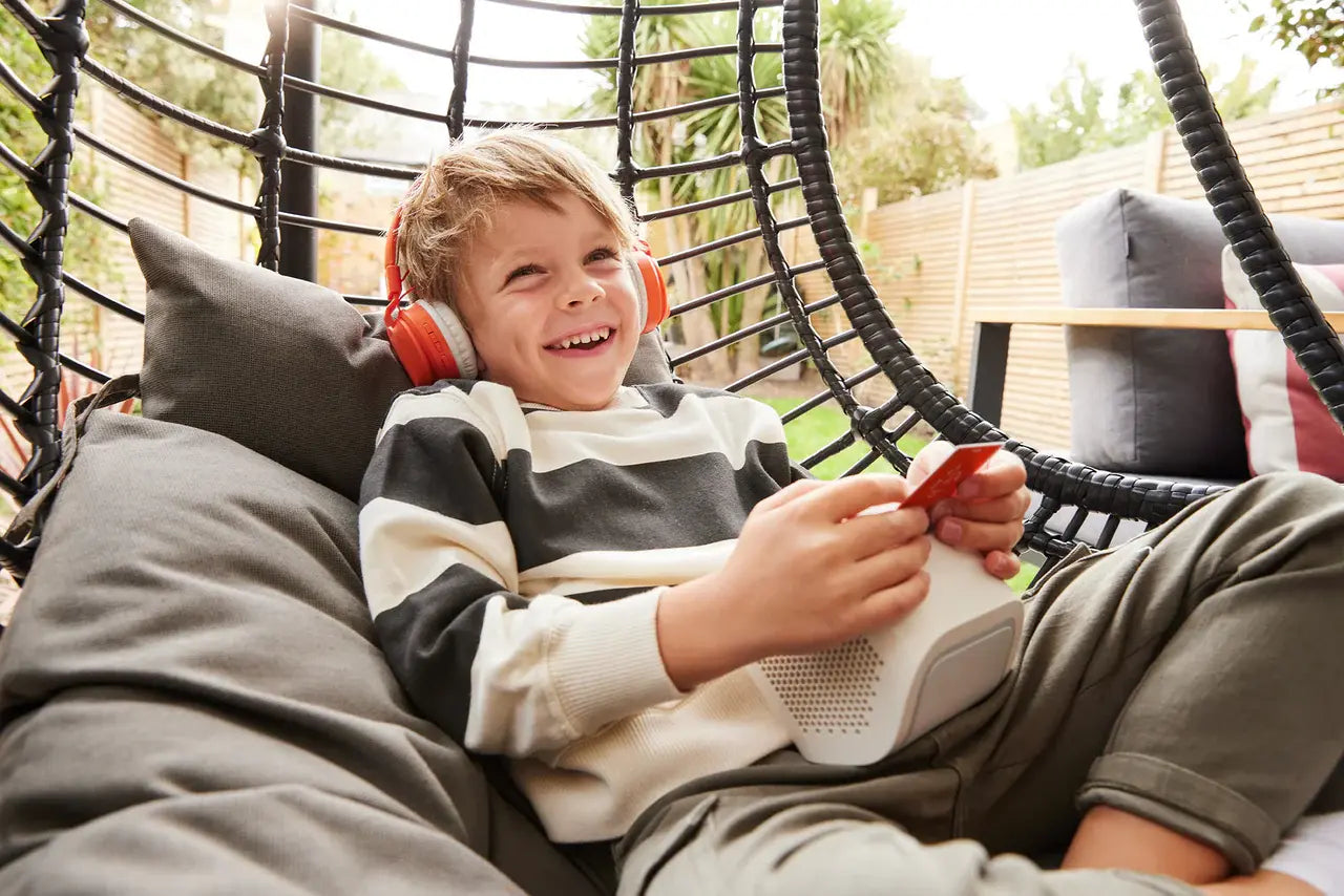 A boy wearing an orange headphone