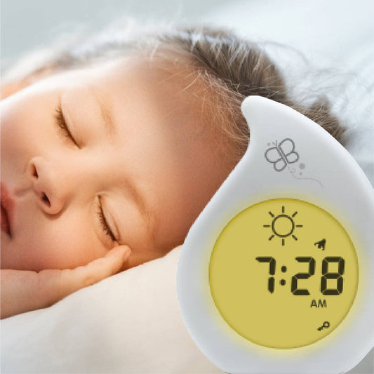 Baby sleeping with a digital clock showing 7:28 AM.